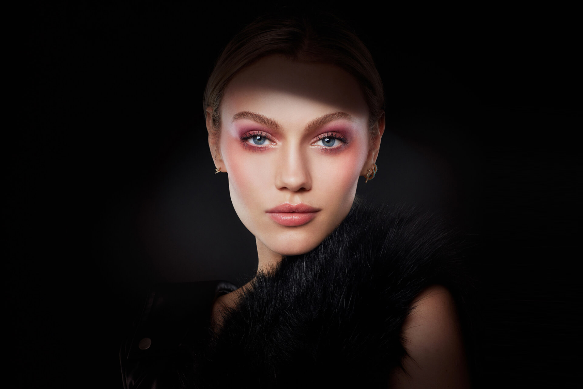 Editorial pink eye makeup portrait on black